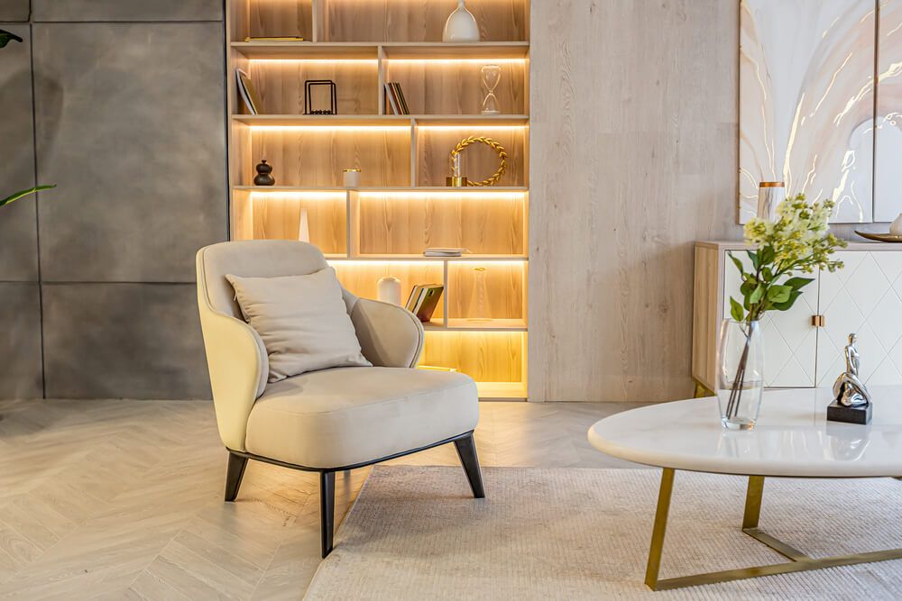 Decorative built-in bookshelf with recessed lighting and soft beige furniture