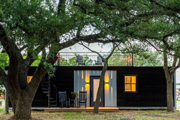 Une maison container à l'extérieur, entre des arbres