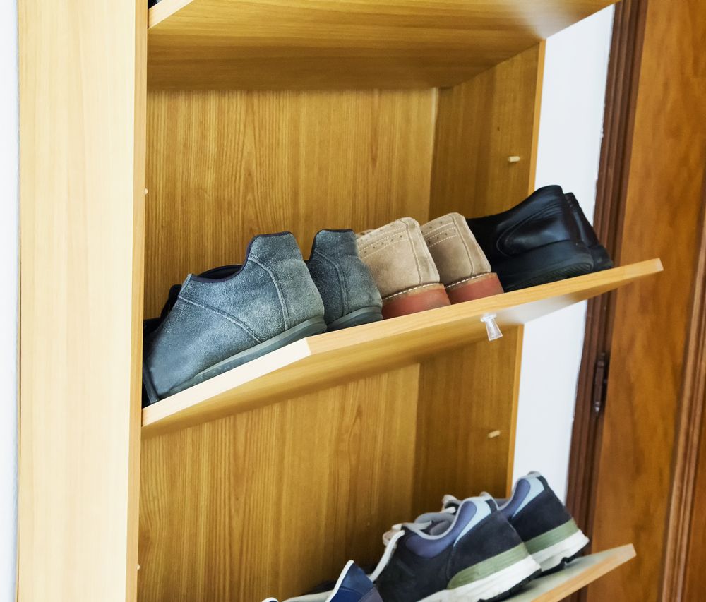 Two shelves of shoes in a cabinet